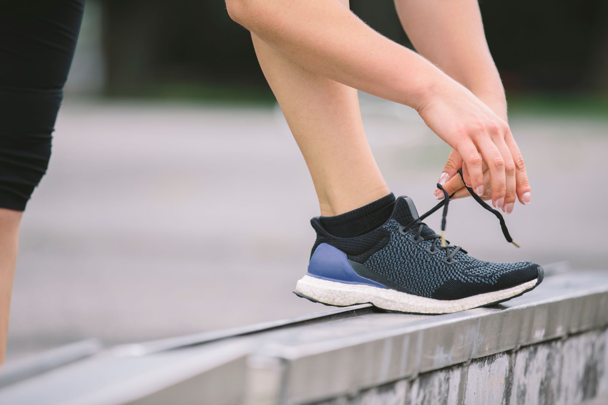 Sportswoman tying shoe on concrete