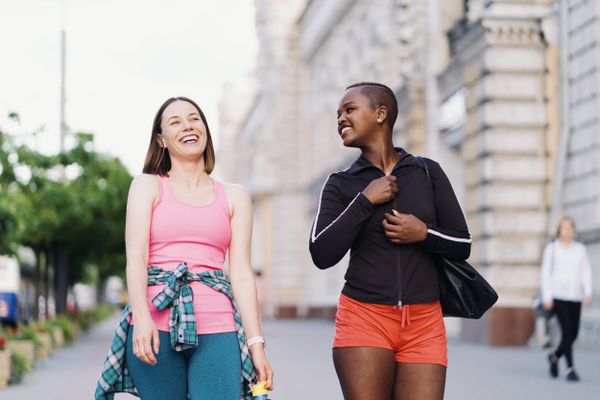 Two multiethnic girls walking for a exercise session, outdoor communicating